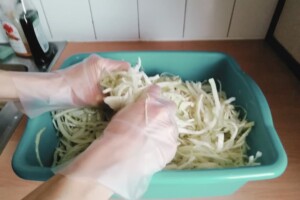 Image showing hands massaging and kneading the cabbage and salt together.