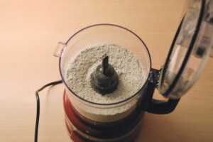 Blended oats in a food processor, turning into fine flour.
