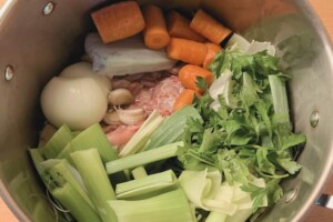 Carrots, leeks, celery, onion, and garlic cloves in a large stock pot.