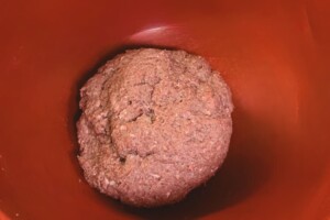 Mixture for meatballs in a red bowl.