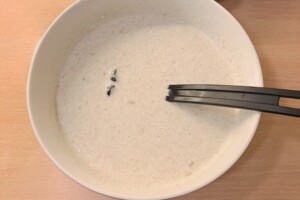 Wet and dry ingredients ingredients are whisked together for oat waffles.