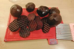 Beets that have been cut are now on a red cutting board.
