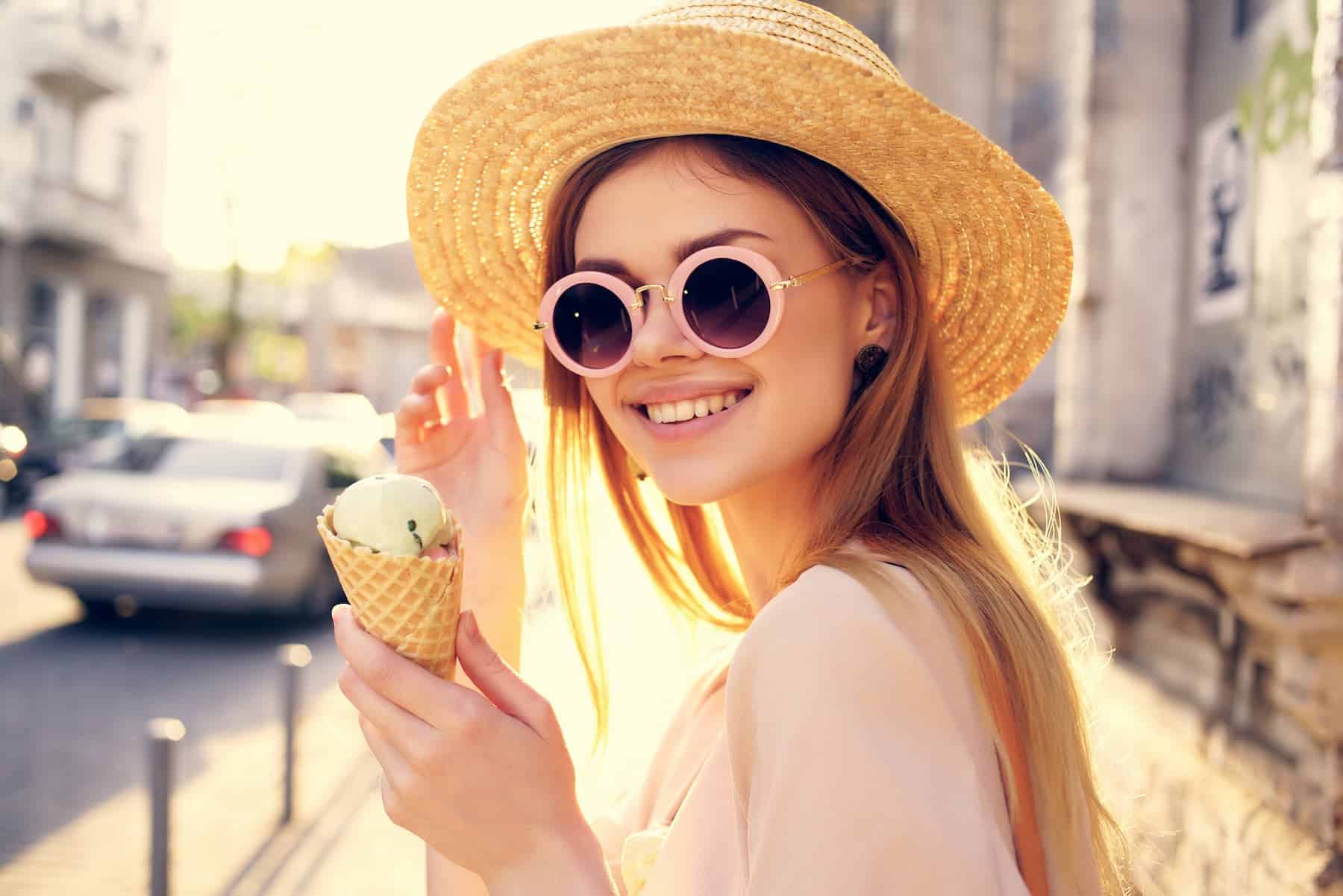 A woman indulges in a scoop of ice cream, blissfully unaware of the potential risks associated with emulsifiers commonly found in ultra-processed foods.