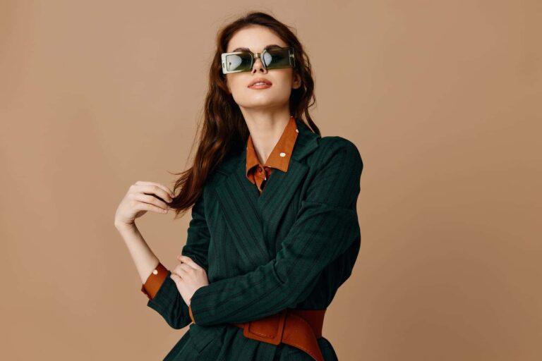 Effortlessly radiant, a beautiful woman in sunglasses poses for the camera, embodying what it means to be naturally thin in a healthy way.