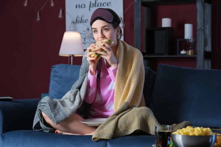 A young woman eating unhealthy food at night, unaware of how to fix skinny fat.