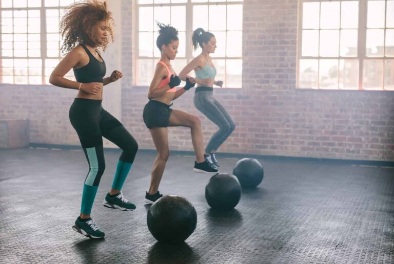 Women doing alternating toe-touch jumps on balls, showing fun exercise ideas for an enjoyable workout.