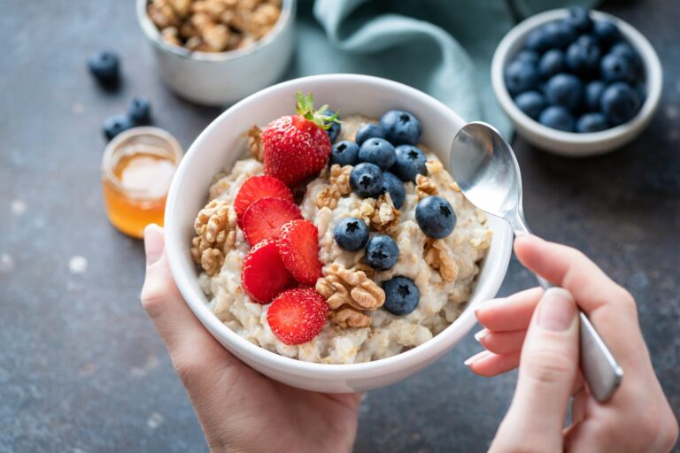 A bowl of oatmeal topped with strawberries, blueberries, and walnuts — a nourishing anti inflammation breakfast rich in fiber and antioxidants.