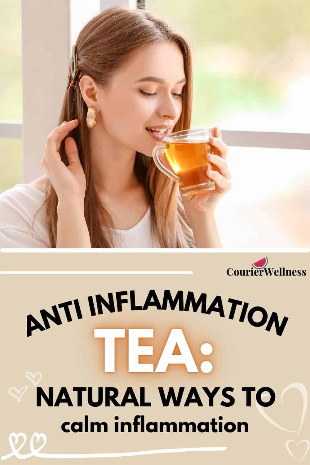 Woman drinking warm anti-inflammation tea from glass mug, hand resting in her hair with a relaxed smile.