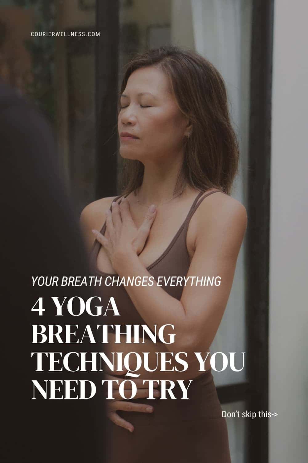 Woman practicing yoga with eyes closed, one hand on her chest and the other on her stomach, focusing on breath.