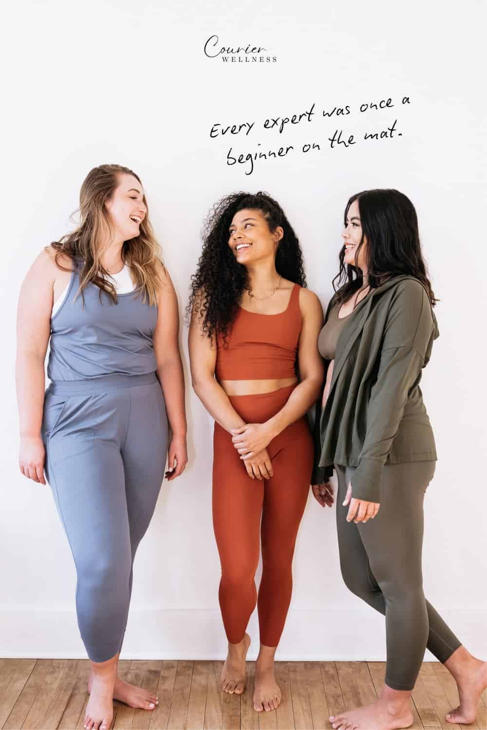 Friends laughing together after a yoga class in a bright studio.