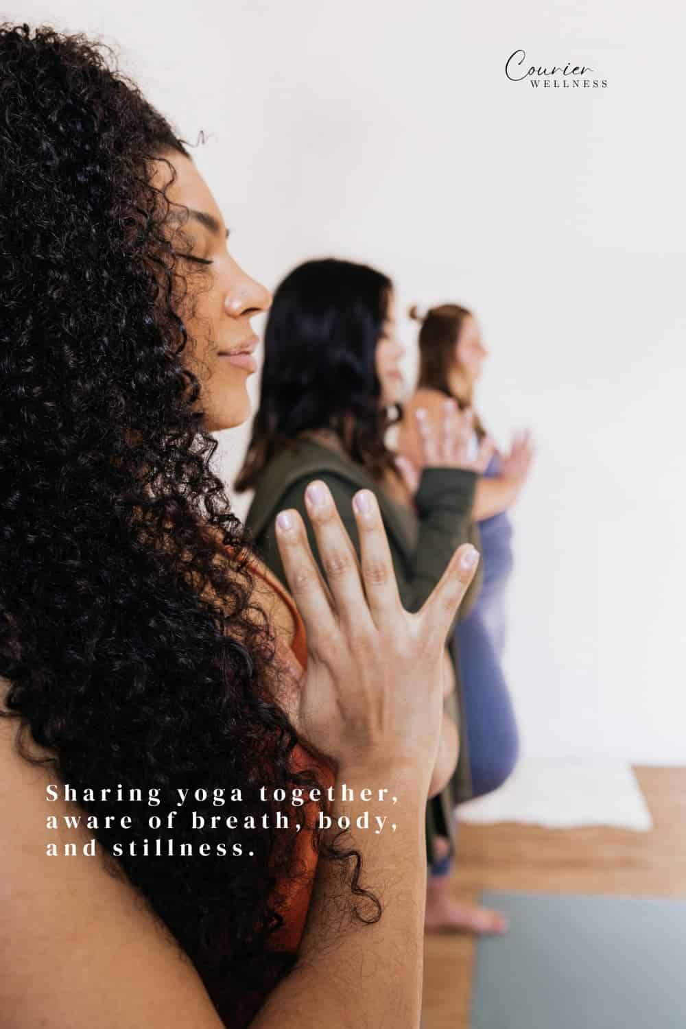 Women stretching and breathing together during a group yoga class.