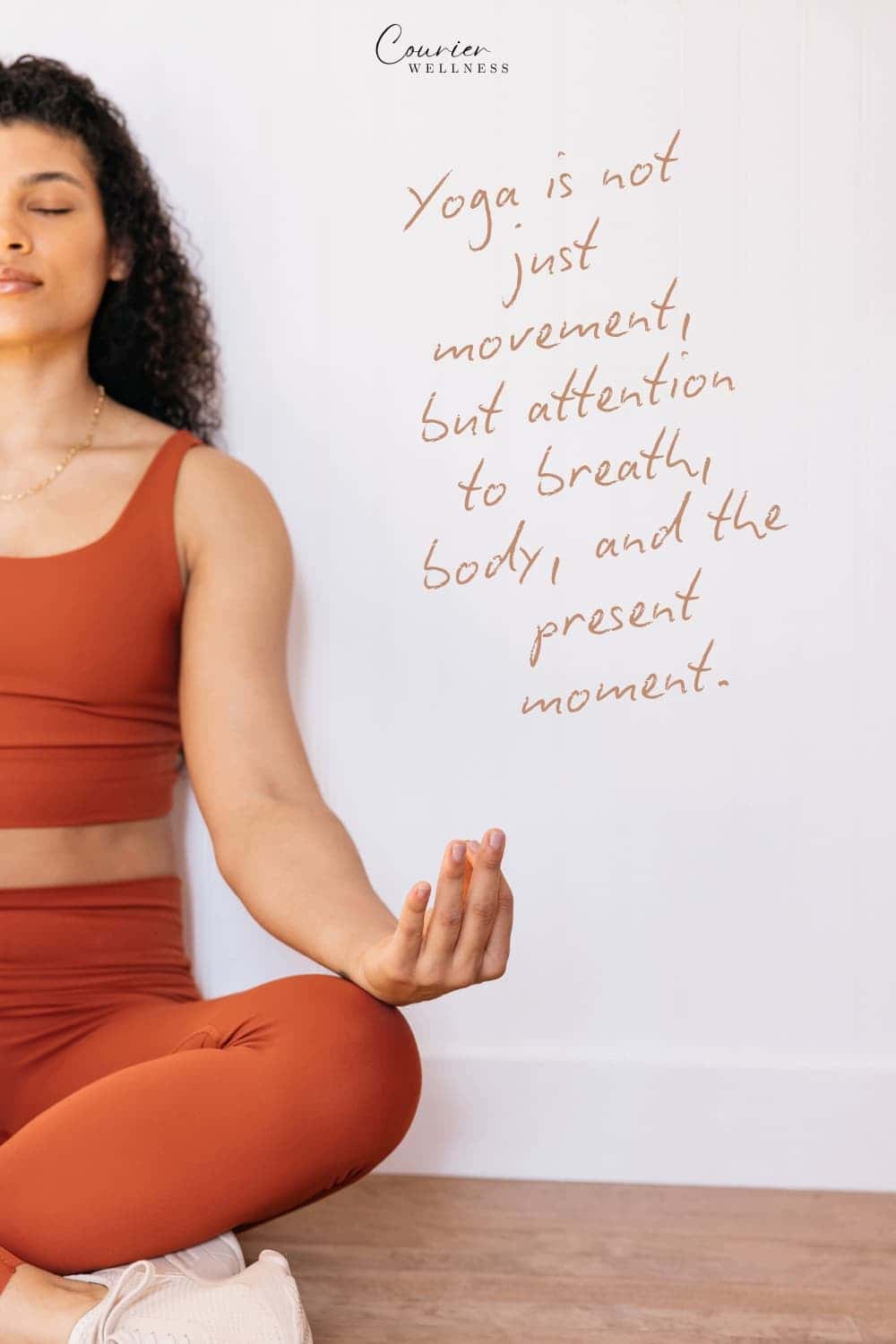 Woman in burnt orange outfit practicing deep breathing exercise while seated on the floor.
