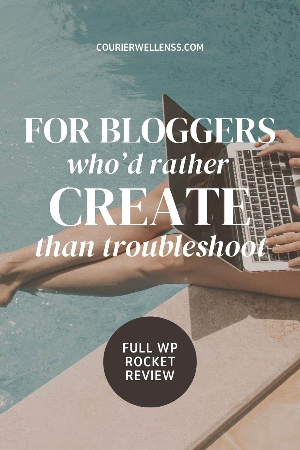 A person's legs are submerged in a swimming pool while they work on a laptop on the pool deck.